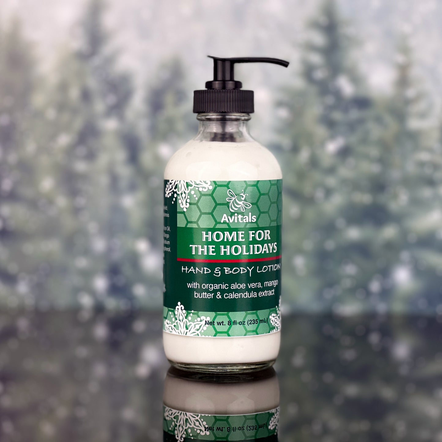 A bottle of Avital's Home for The Holidays Hand and Body Lotion on a green and sparkle background.