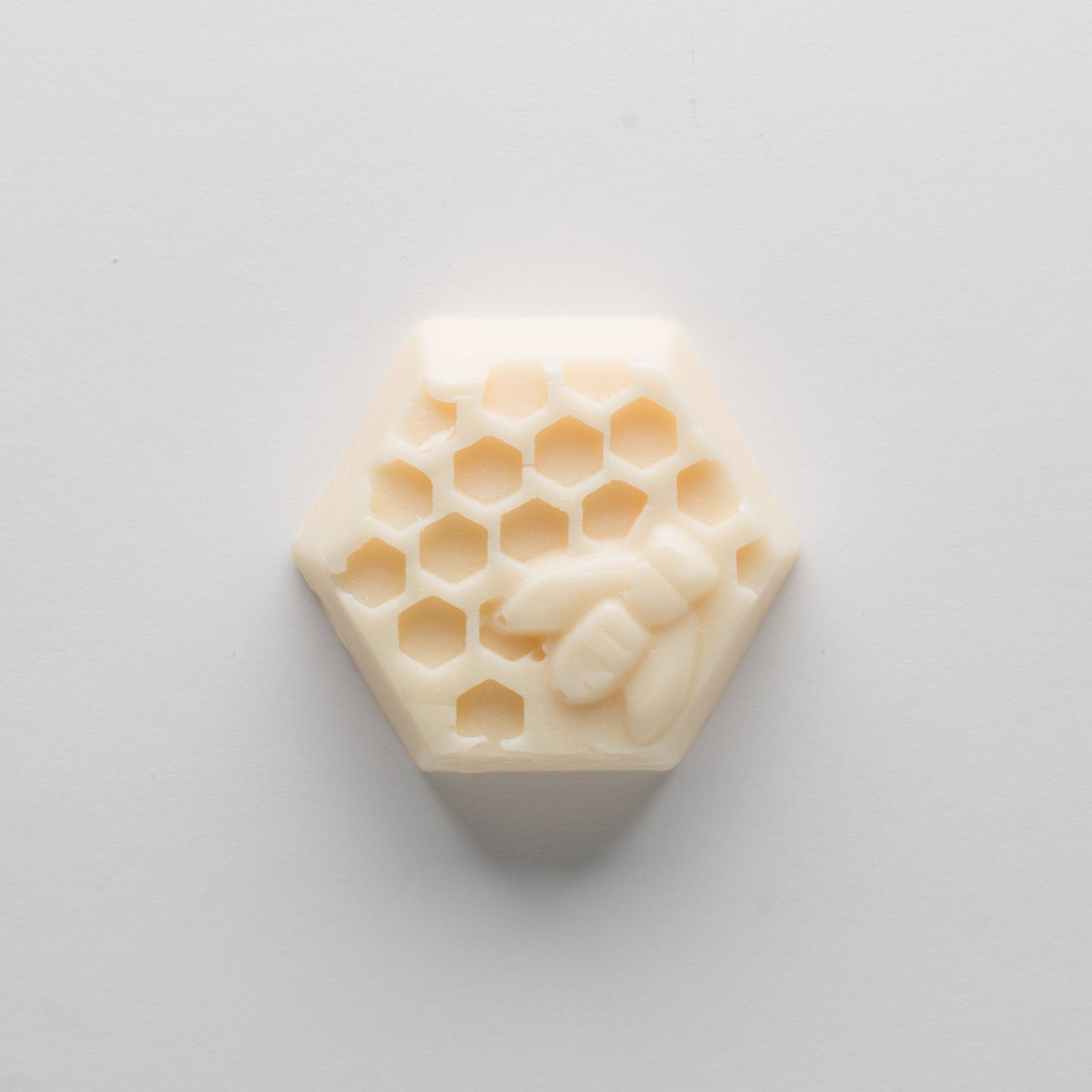
                  
                    A cream-colored, hexagonal bar with a honey be and hexagon motif.
                  
                