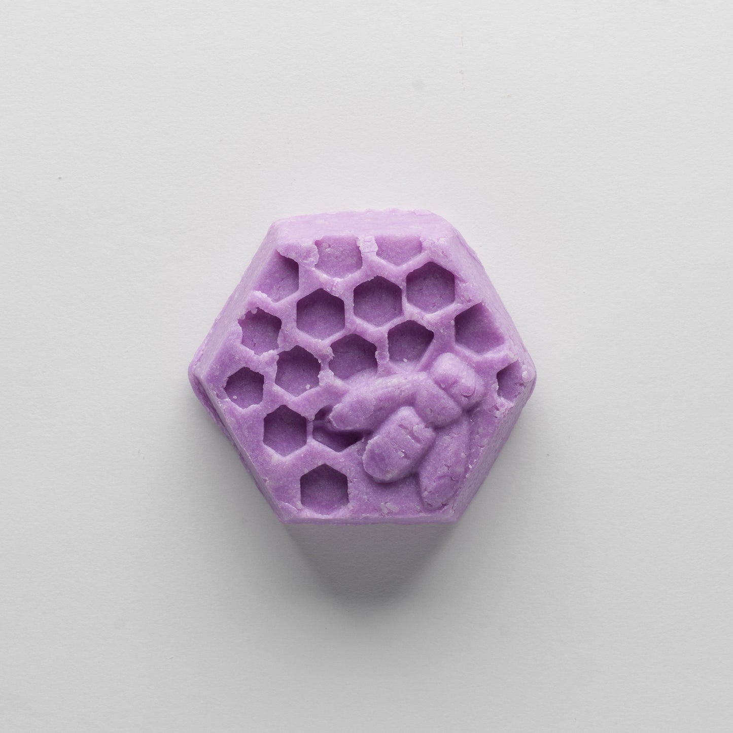 A purple hexagonal bar that depicts a honey bee on honey comb.