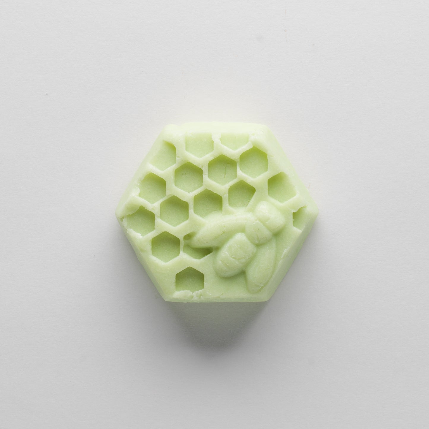 Green hexagonal bar with honey bee and honeycomb on the top