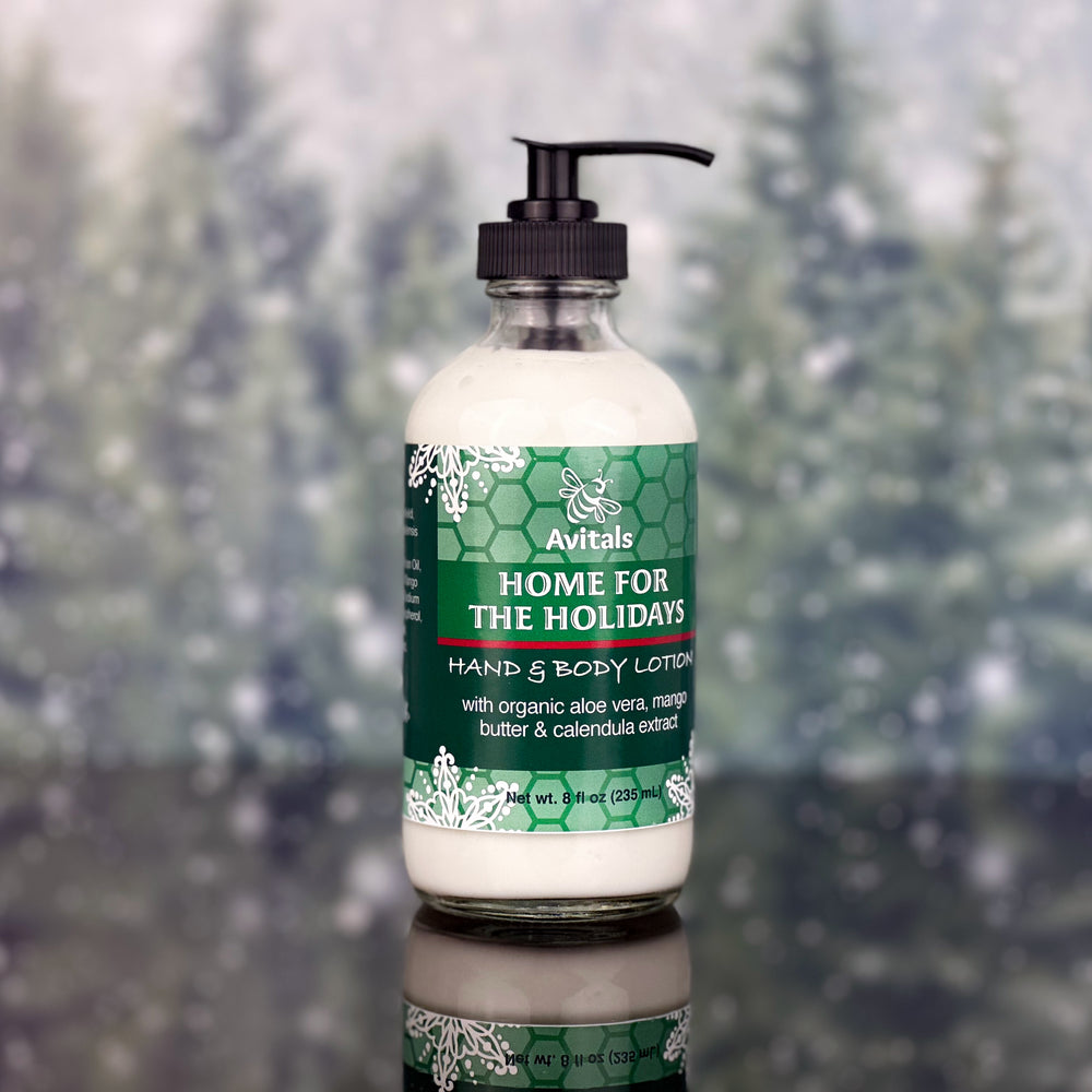A bottle of Avital's Home for The Holidays Hand and Body Lotion on a green and sparkle background.