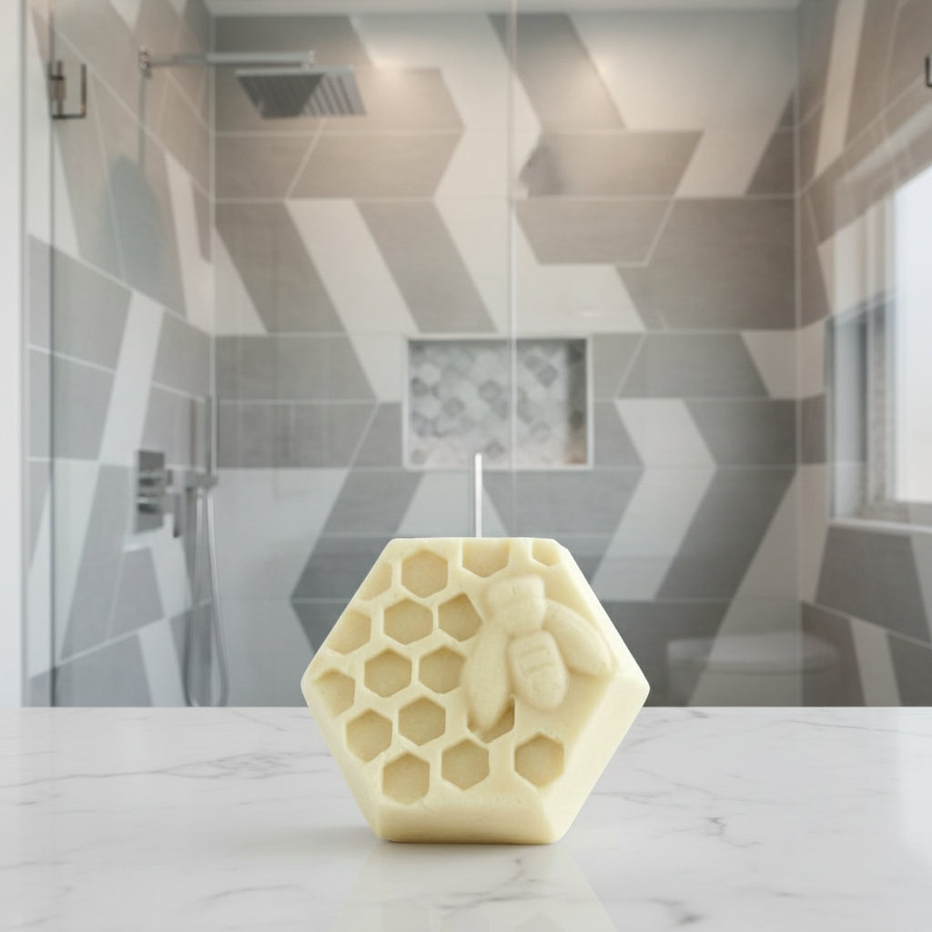 Hexagonal soap bar with honeycomb and bee design in a modern, tiled shower