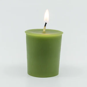 
                  
                    A lit green votive candle with a center wick.
                  
                