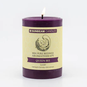 
                  
                    A lit deep purple pillar candle with a paper label.
                  
                