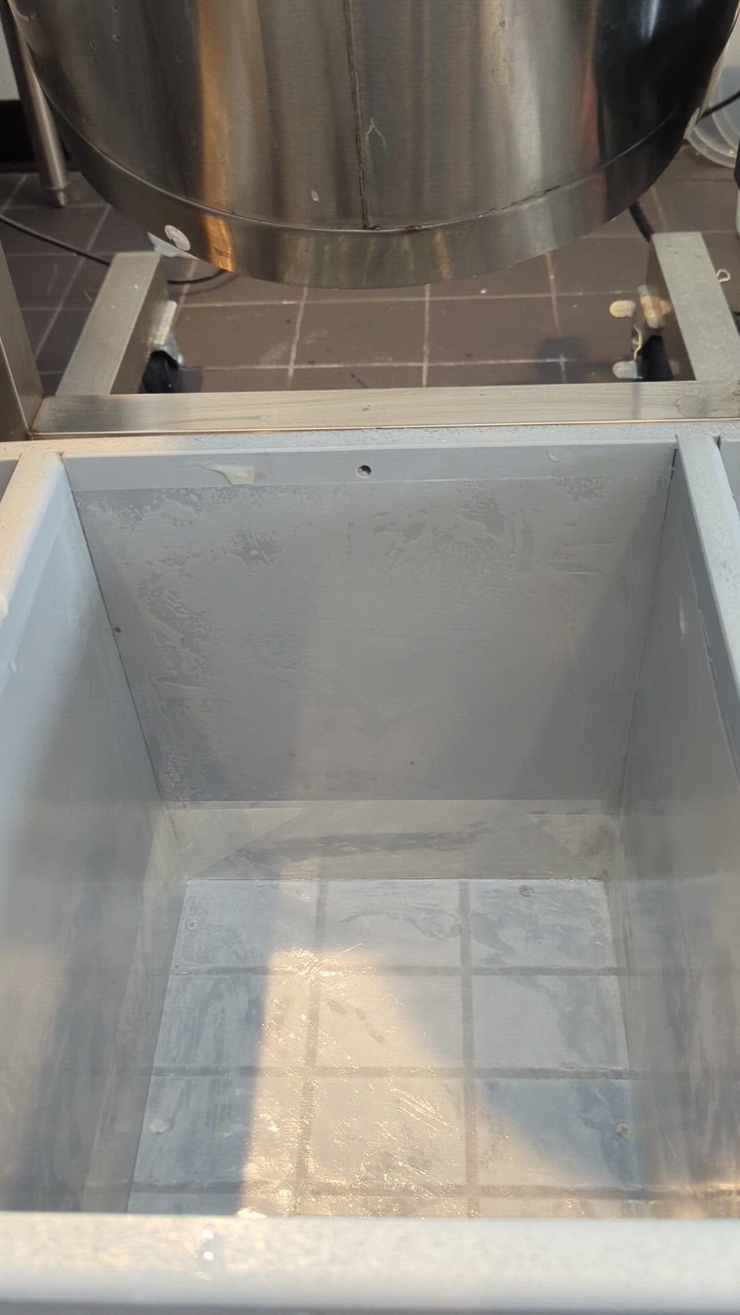 A video of a large block of black, purple, and green soap being poured.