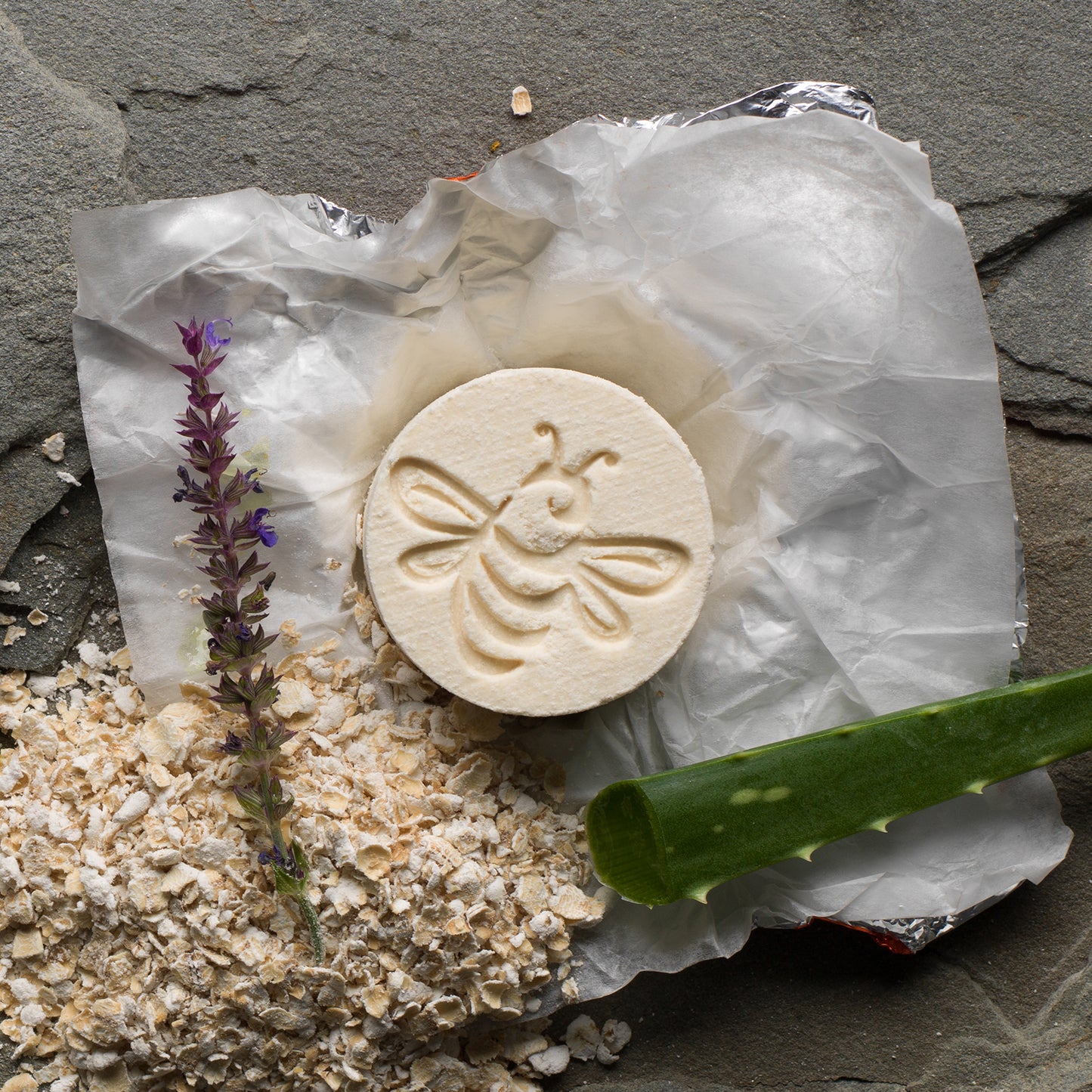 So luscious! Bee stamped cylinder bath fizzy with a sprig of lavender, a pile of oatmeal, and an aloe leaf. 