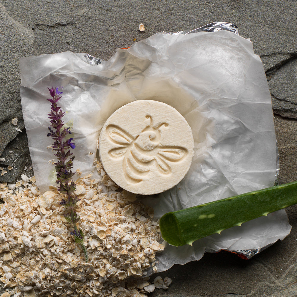 So luscious! Bee stamped cylinder bath fizzy with a spring of aloe, a pile of oatmeal, and an aloe leaf. 