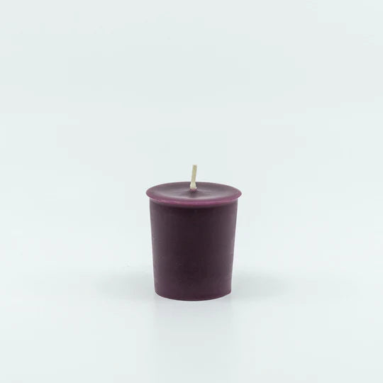 
                  
                    A deep purple votive candle with a center wick.
                  
                